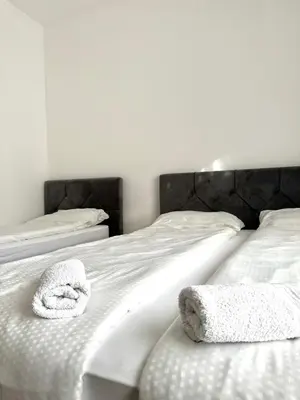 two white towels sitting on top of a bed at L&L rooms in Maribor