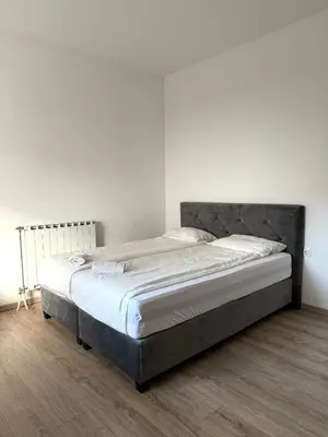 a large bed in a bedroom with a wooden floor at L&L rooms in Maribor