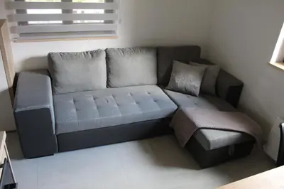 a living room with a couch and a ottoman at Apartment Bajta - Rogla in Zreče