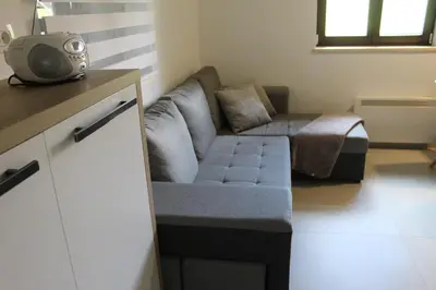 a living room with a couch and a tv in it at Apartment Bajta - Rogla in Zreče