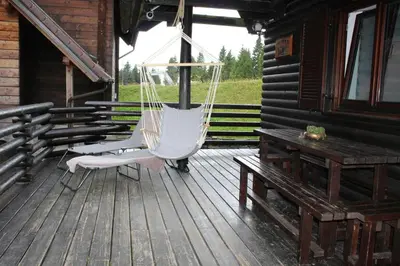 a porch with a hammock on a house at Apartment Bajta - Rogla in Zreče