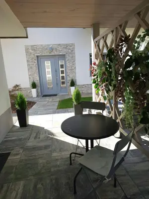 a patio with a table and chairs and a door at Prima Countryside Apartments in Žirovnica