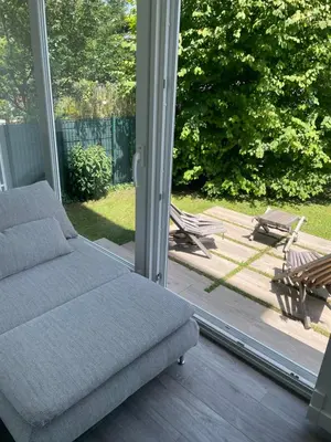 a couch sitting on a porch with a sliding glass door at HAY Apartment Bled in Bled