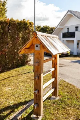 a wooden bird house with a roof on the grass at HAY Apartment Bled in Bled