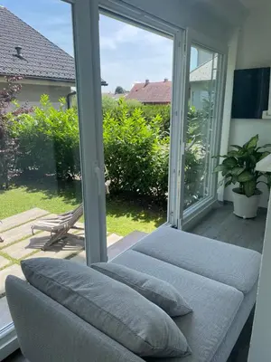 a couch sitting in front of a sliding glass door at HAY Apartment Bled in Bled