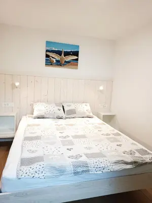a bedroom with a large bed with a picture on the wall at Siesta apartment Bled in Bled