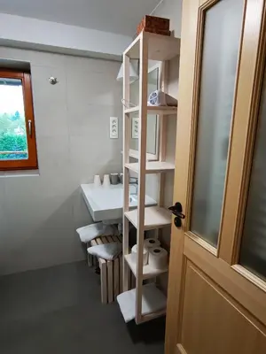 a bathroom with a sink and a shelf with towels at Siesta apartment Bled in Bled