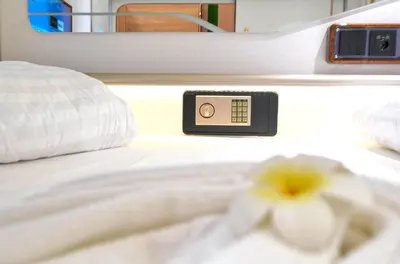 a white bed with a white flower on it at Ljubljana Capsule Hostel in Ljubljana