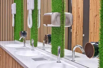 a bathroom with three sinks with green moss on the wall at Ljubljana Capsule Hostel in Ljubljana