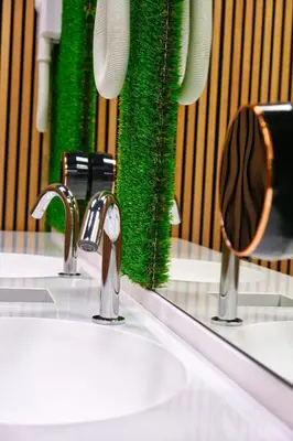 a bathroom sink with two faucets and a mirror at Ljubljana Capsule Hostel in Ljubljana