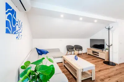 a living room with a couch and a tv at Apartmaji Mouse in Bovec