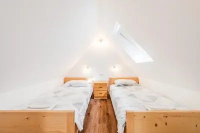 two beds in a room with a roof at Apartmaji Mouse in Bovec