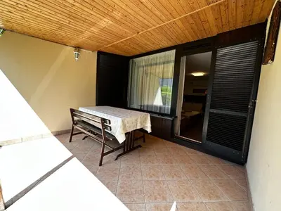 a patio with a table and a bench on a balcony at Vivo Bovec in Bovec