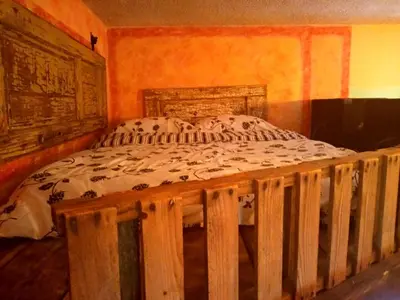 a bed in a room with a wooden frame at Krasberry Ježev brlog in Komen