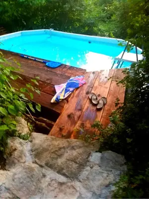a pair of shoes sitting on a wooden deck next to a swimming pool at Krasberry Ježev brlog in Komen