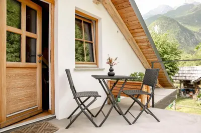 a table and chairs on the porch of a house at Apartma Mlekuž in Bovec