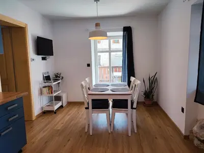 a table and chairs in a room with a window at Corner House Apartments near Lake Bled in Radovljica