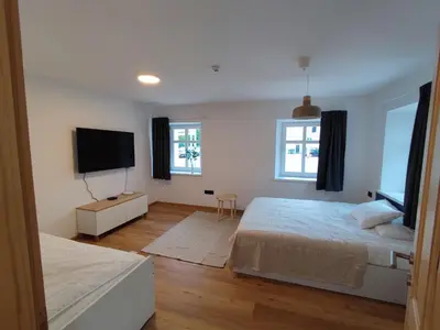 a bedroom with two beds and a flat screen tv at Corner House Apartments near Lake Bled in Radovljica