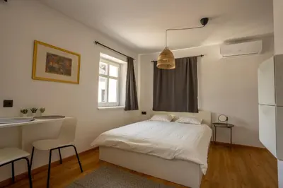 a bedroom with a bed and a desk and a window at Corner House Apartments near Lake Bled in Radovljica