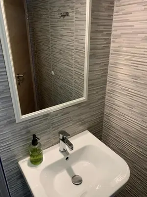 a bathroom with a white sink and a mirror at L&G ROOMS in Ljubljana