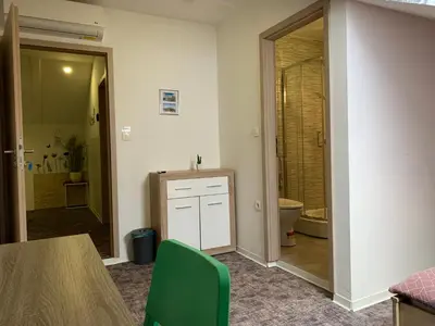 a room with a bathroom with a toilet and a table at L&G ROOMS in Ljubljana