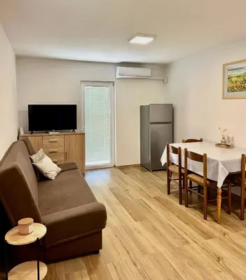 a living room with a couch and a table at Holiday House Tomajna in Podlehnik