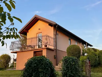 a house with a balcony on top of it at Holiday House Tomajna in Podlehnik