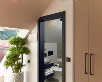 a bathroom with a toilet and a mirror at The Hotel Ljubljana in Ljubljana
