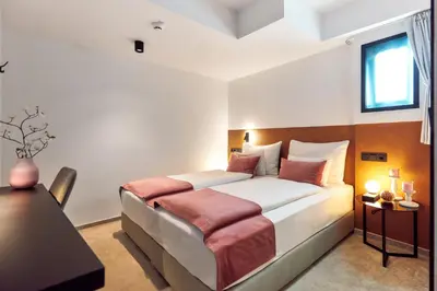a bedroom with a bed and a table and a window at The Hotel Ljubljana in Ljubljana