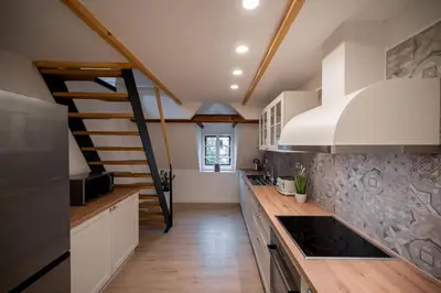 a kitchen with white cabinets and a staircase at House Leska in Kranjska Gora