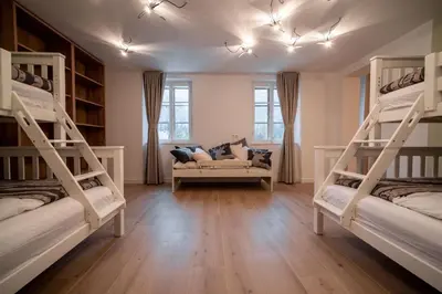 a room with three bunk beds and a couch at House Leska in Kranjska Gora