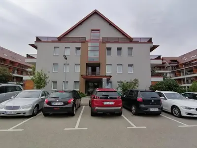 a parking lot with cars parked in front of a building at Apartma Petja in Moravske Toplice