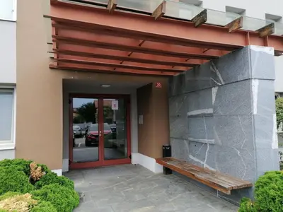 a building with a bench in front of a door at Apartma Petja in Moravske Toplice