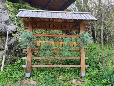 a wooden pergola with flowers in a garden at Apartma Lara in Bled
