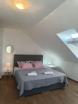 a bedroom with a large bed with pink pillows at Sobe pri Roži in Postojna