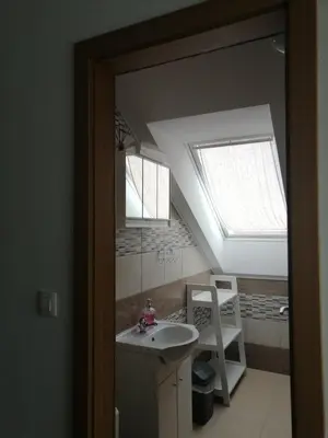a bathroom with a sink and a skylight at Sobe pri Roži in Postojna
