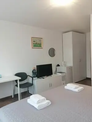 a white room with a desk and a chair at Sobe pri Roži in Postojna
