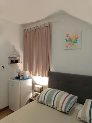 a bedroom with a bed and a dresser and a window at Sobe pri Roži in Postojna