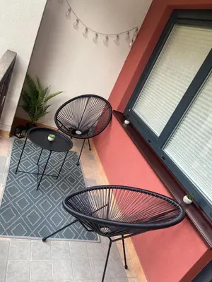two chairs and a table in front of a wall at Bee's Place Holiday Home Kranjska Gora in Kranjska Gora
