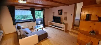 a living room with a couch and a tv at Apartma Vidic in Gozd Martuljek