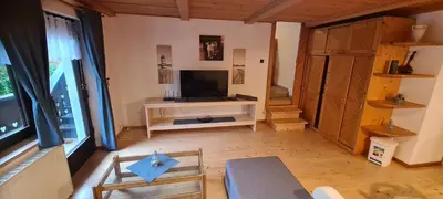a living room with a flat screen tv and a table at Apartma Vidic in Gozd Martuljek