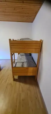 a wooden bunk bed in a corner of a room at Apartma Vidic in Gozd Martuljek