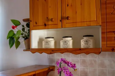 a kitchen shelf with three candles on it at Apartma Na skdnu in Dutovlje