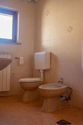 a bathroom with a toilet and a sink at Apartma Na skdnu in Dutovlje