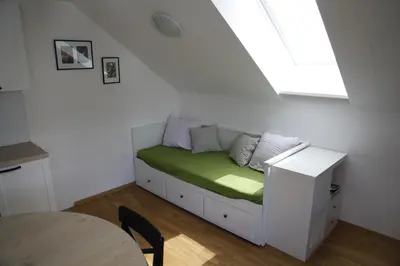 a small bed in a room with a window at Family apartment on Repečnik farm in Gorje, Bled in Zgornje Gorje