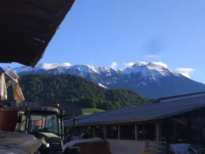 a truck parked in front of a building with a mountain at Family apartment on Repečnik farm in Gorje, Bled in Zgornje Gorje