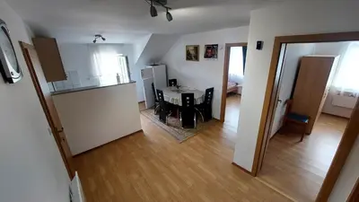 a kitchen and a living room with a table at Apartma ASJA in Brežice