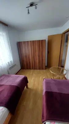 a bedroom with two beds and a glass table at Apartma ASJA in Brežice