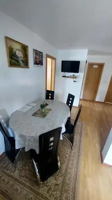 a table and chairs in a living room with a table at Apartma ASJA in Brežice