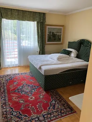 a bedroom with a large bed with a red rug at Apartment Lucy, Bled in Bled